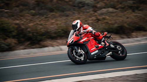 A Man Riding Red Sports Bike on the Road