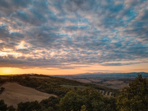 Free Breathtaking aerial landscape showcasing rolling hills under a vibrant sunset sky. Stock Photo