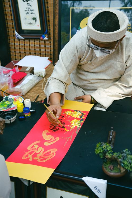 Free An Asian calligraphy master skillfully painting calligraphy art at a workspace. Stock Photo