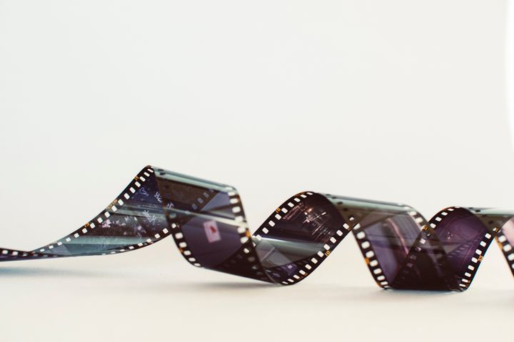 Tira de película enrollada sobre una superficie blanca con luz suave