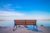 平静的海洋边有一张木凳，天空充满活力