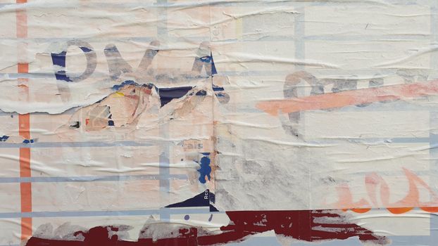A close-up image of a worn and layered street poster showcasing abstract textures and colors.