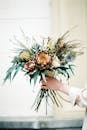 Unrecognizable Female Hand Holding Bunch of Exotic Extraordinary Flowers