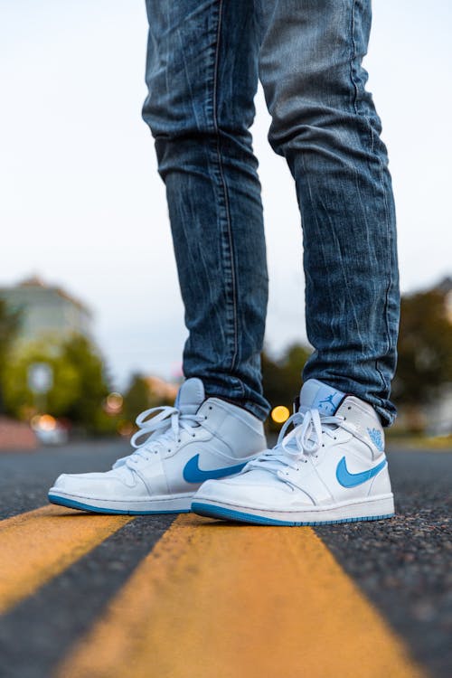 Person Wearing White And Blue Air Jordan 1's · Free Stock Photo