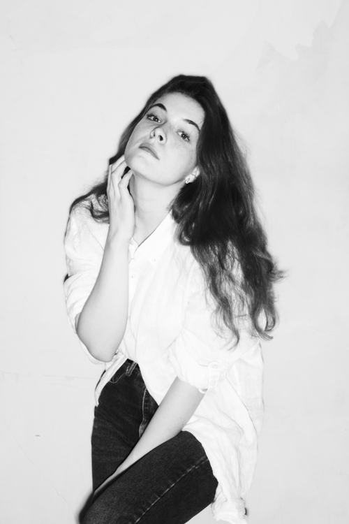 Free Elegant black and white portrait of a woman in a white shirt, posing thoughtfully. Stock Photo