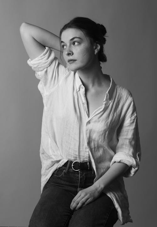 A Woman in White Button Up Shirt and Blue Denim Jeans