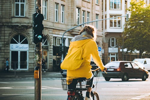 Donna Che Indossa Cappotto Con Cappuccio Giallo Bicicletta Equitazione