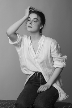 Sophisticated black and white portrait of a young woman posing with closed eyes.