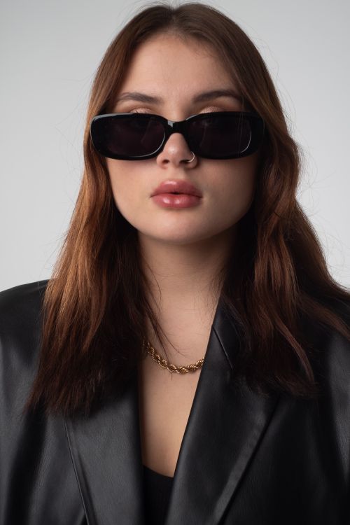 Free Fashion-forward young woman wearing sunglasses and a black leather jacket. Stock Photo