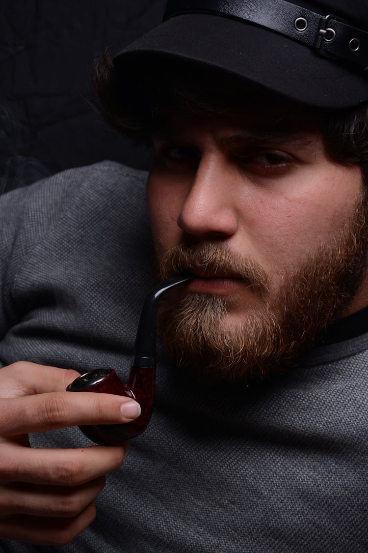 A Man Smoking A Pipe