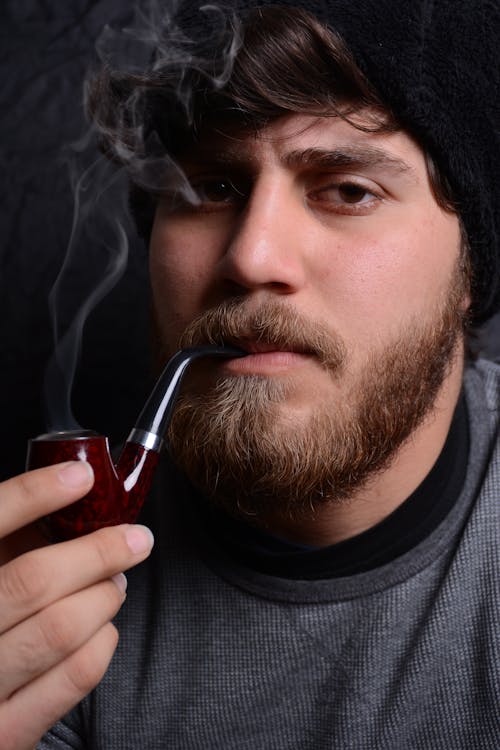 Free A Man Holding a Tobacco Pipe Stock Photo