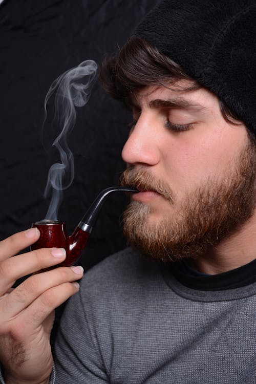 A Man in Black Knit Cap Smoking
