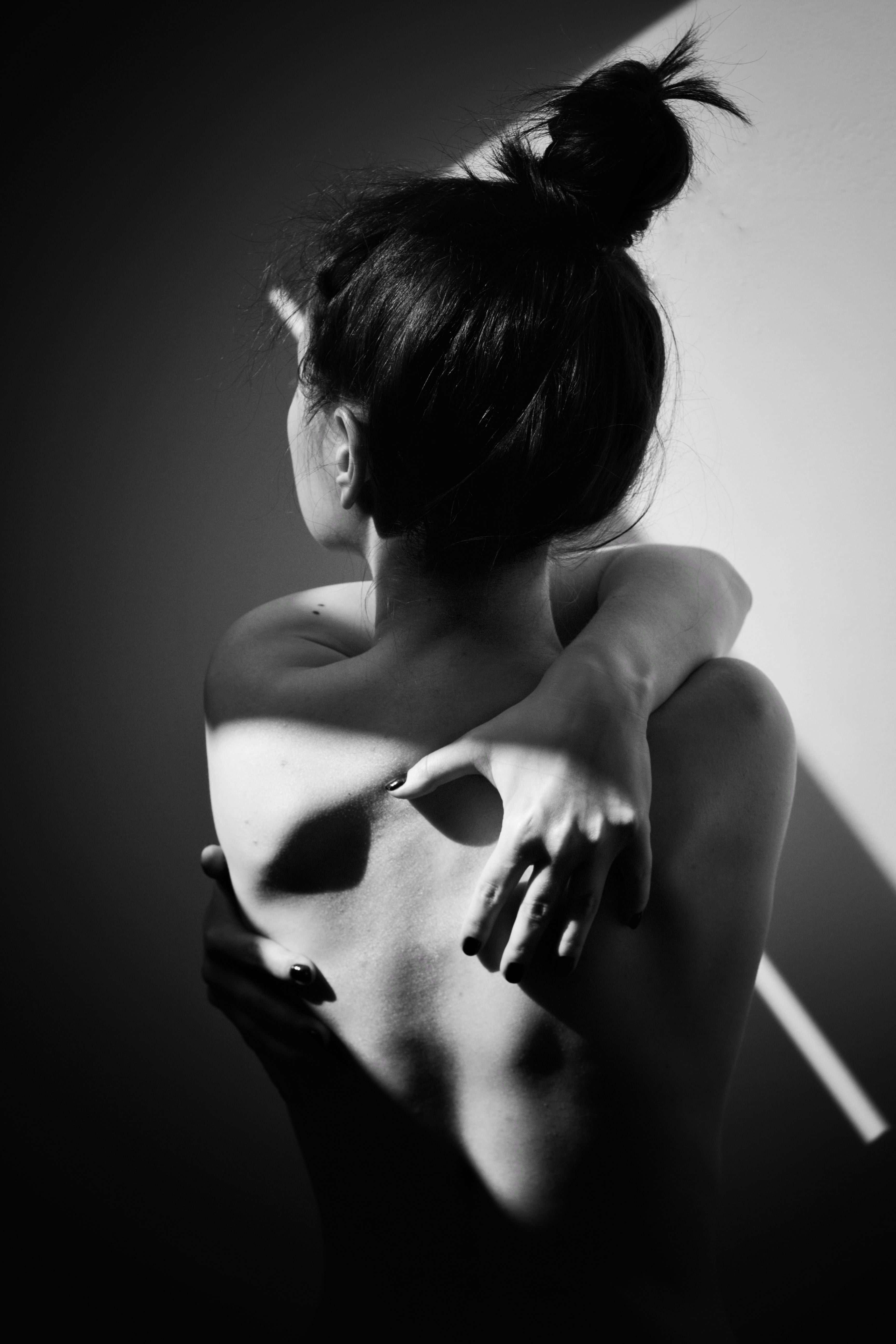 Artistic black and white portrait of a woman from behind, in solitude.
