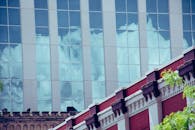 玻璃立面将云层反射到城市建筑上，形成装饰效果