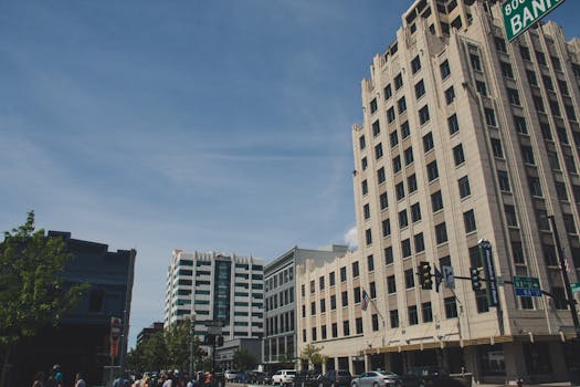 晴朗的天空下，一座繁华的城市街景中矗立着现代建筑与高楼大厦