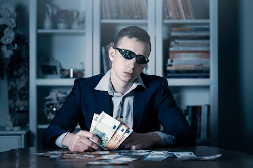 Free Man in Black Blazer and Sunglasses holding Paper Bills  Stock Photo