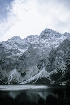 Dramatic Tatra mountains reflected in the calm Morskie Oko lake in Poland.