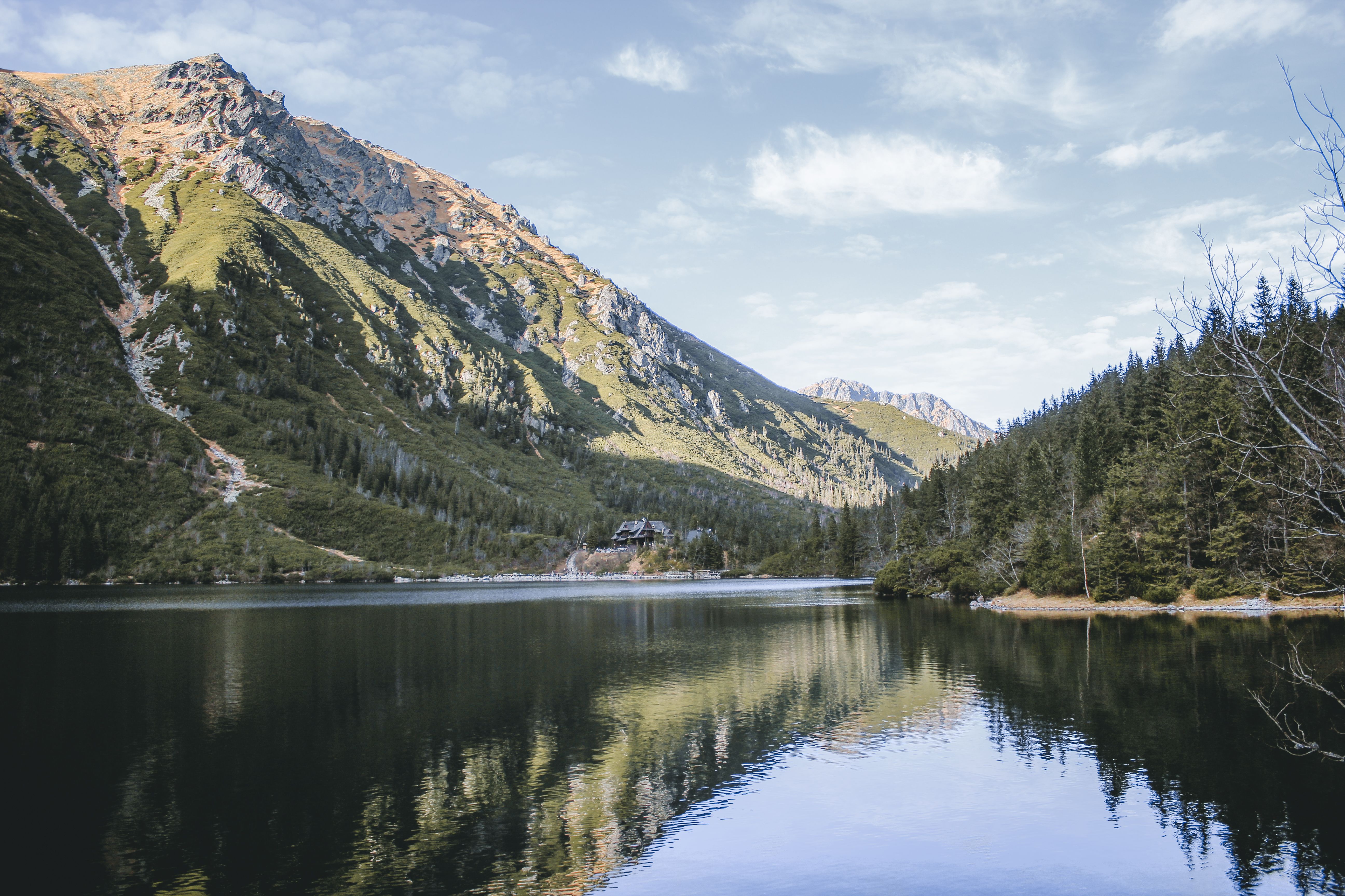 Peaceful view of a mountain lake reflecting the surrounding peaks in Zakopane, Poland.