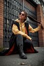 Woman in Black and Yellow Long Sleeve Shirt and Black Pants Sitting on Gray Concrete Floor