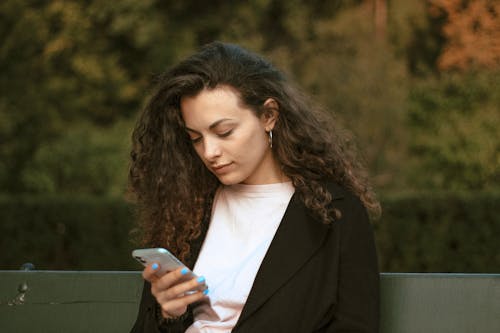 akıllı telefon, bukleli saç, cep telefonu içeren Ücretsiz stok fotoğraf