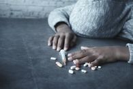 Person Holding Orange and White Medication Pill