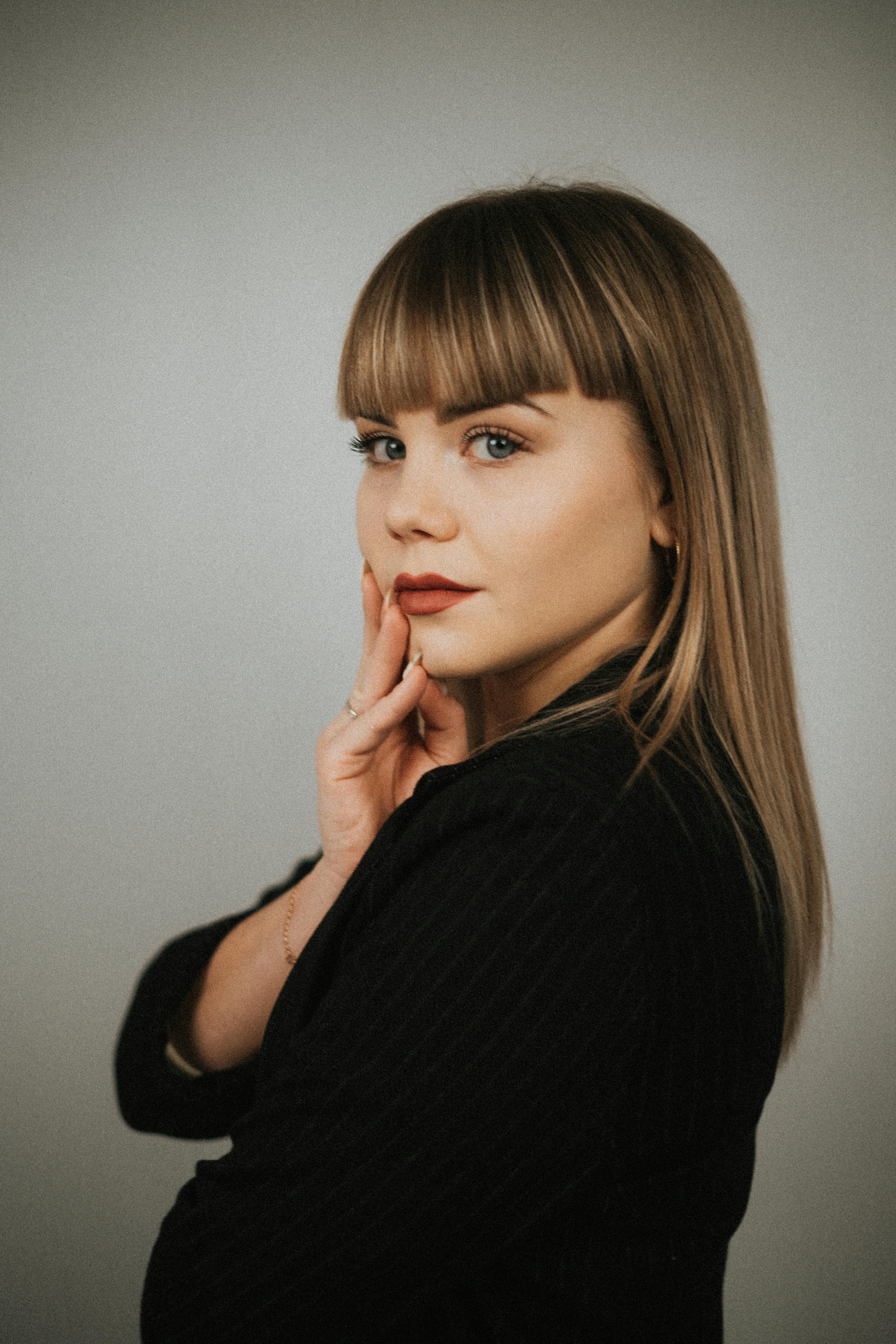 Portrait of a stylish woman with fringe and red lipstick, front-facing with copy space.
