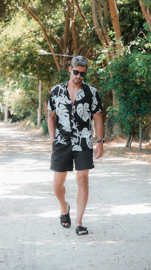 Foto profissional grátis de andando, calção, camisa floral com botões