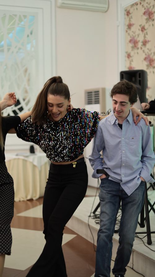Free Two young adults dancing happily indoors during a celebration, exuding joy and connection. Stock Photo