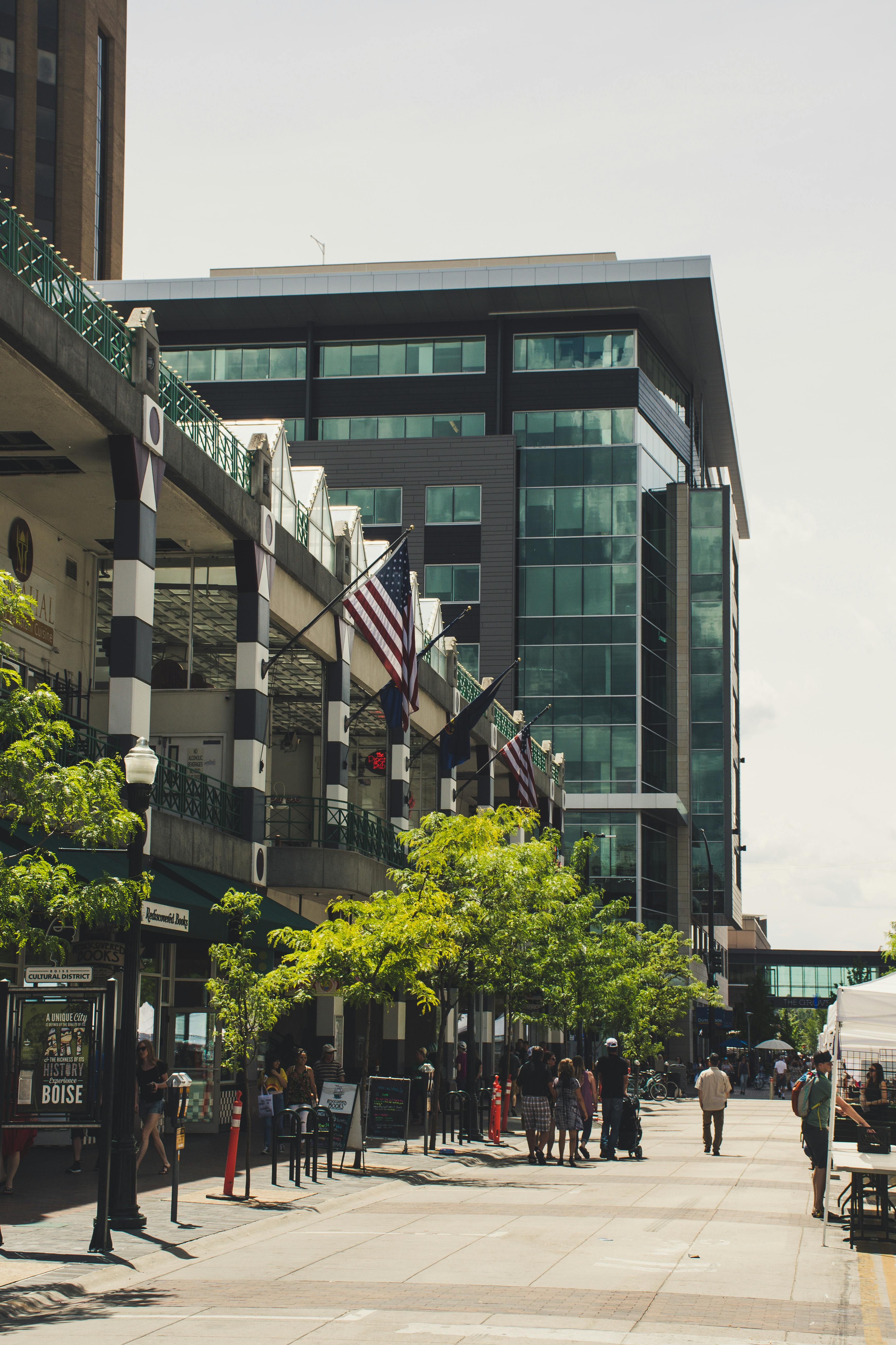 繁华的城市街道两旁，玻璃摩天大楼和旗帜林立，展现了城市生活与现代建筑的魅力