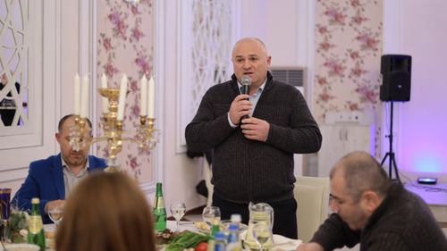Free A man speaking into a microphone during a formal dinner gathering indoors with elegant decor. Stock Photo