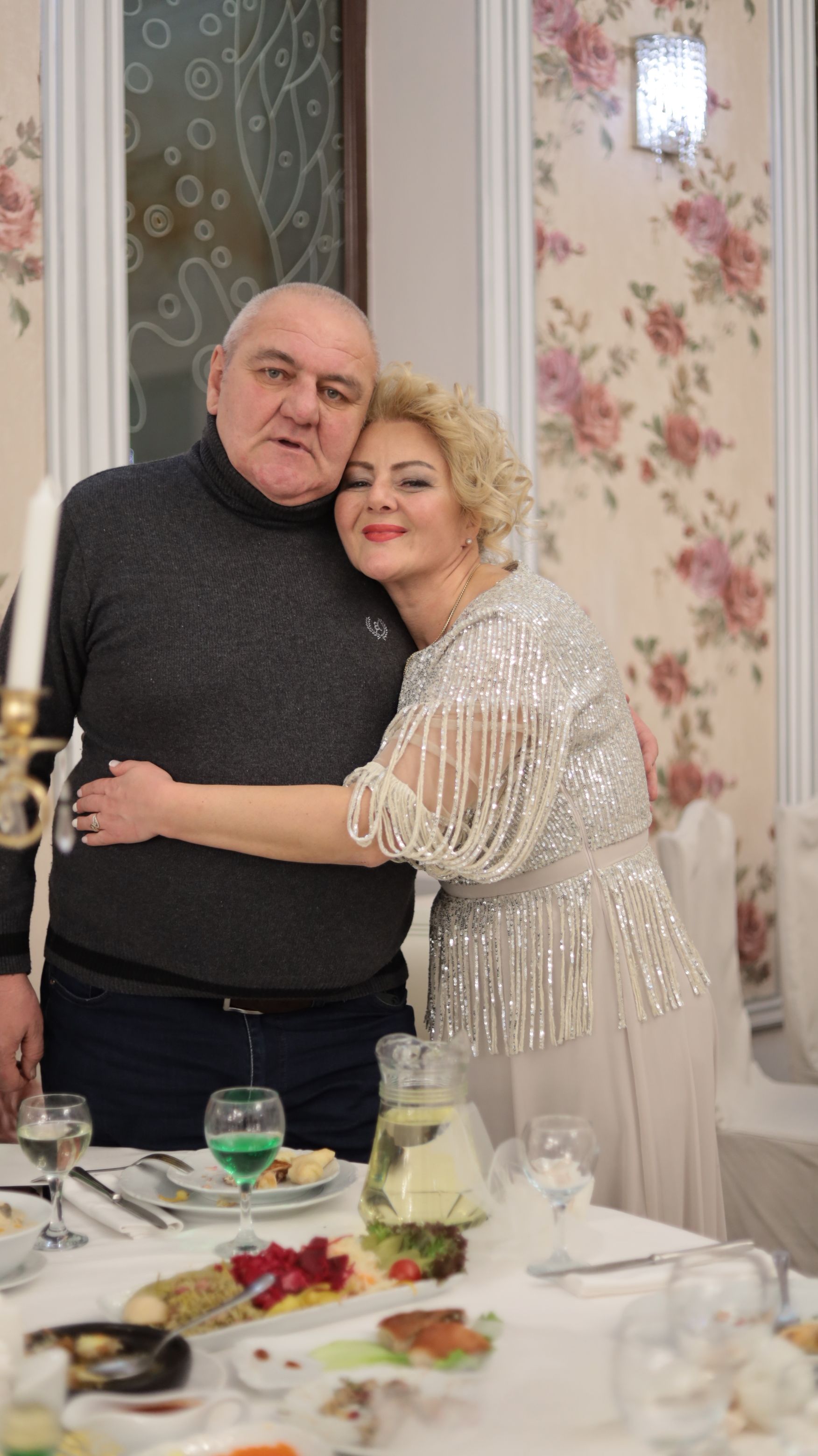 Joyful elderly couple embracing at an elegant indoor celebration, capturing warmth and happiness.