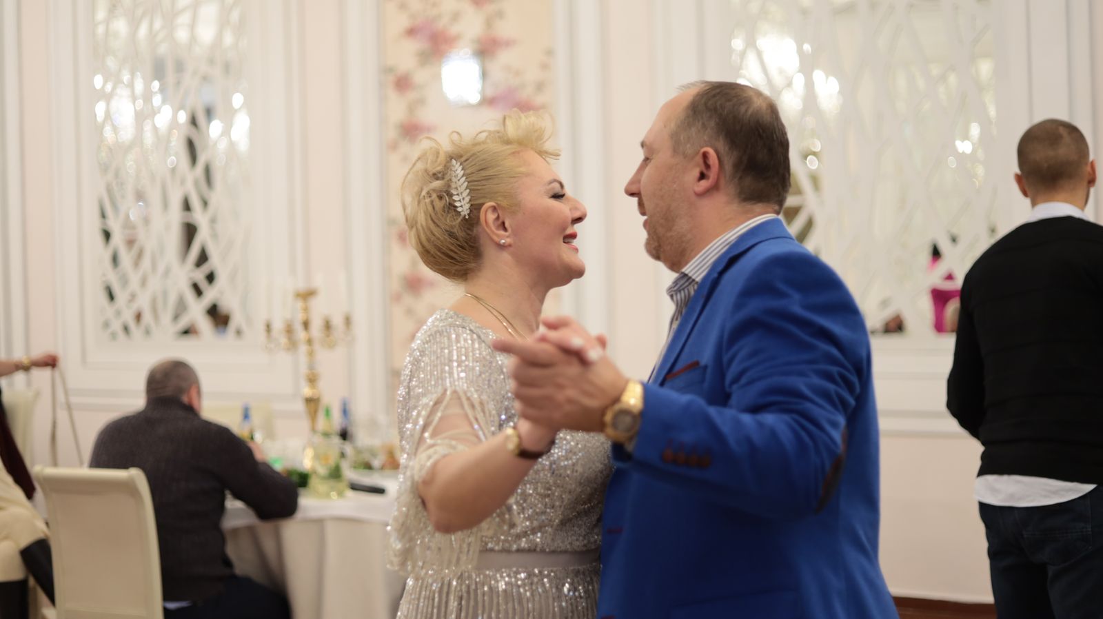 Quickstep — happy mature couple dancing elegantly at an indoor celebration. Stock photo.