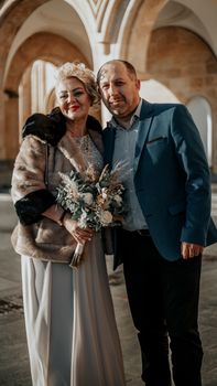 A mature couple in formal attire posing together outdoors, showcasing elegance and togetherness.