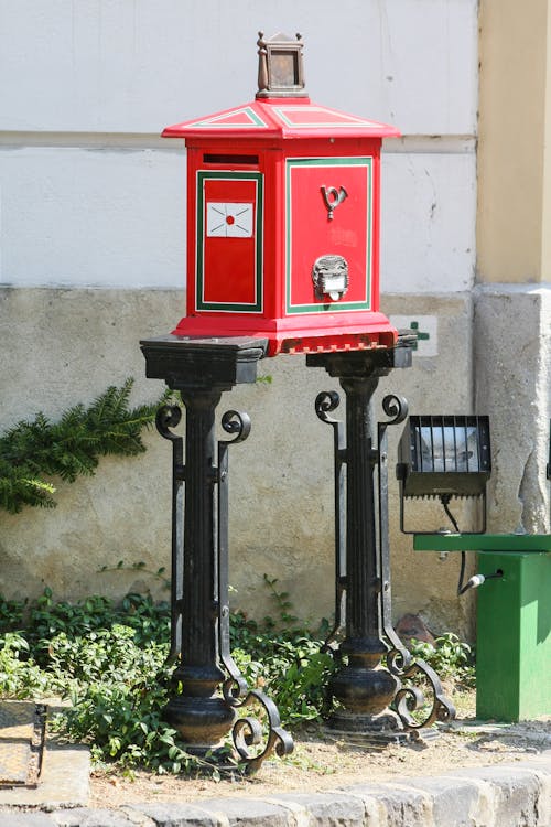 Red Mailbox Beside a Concrete Fence