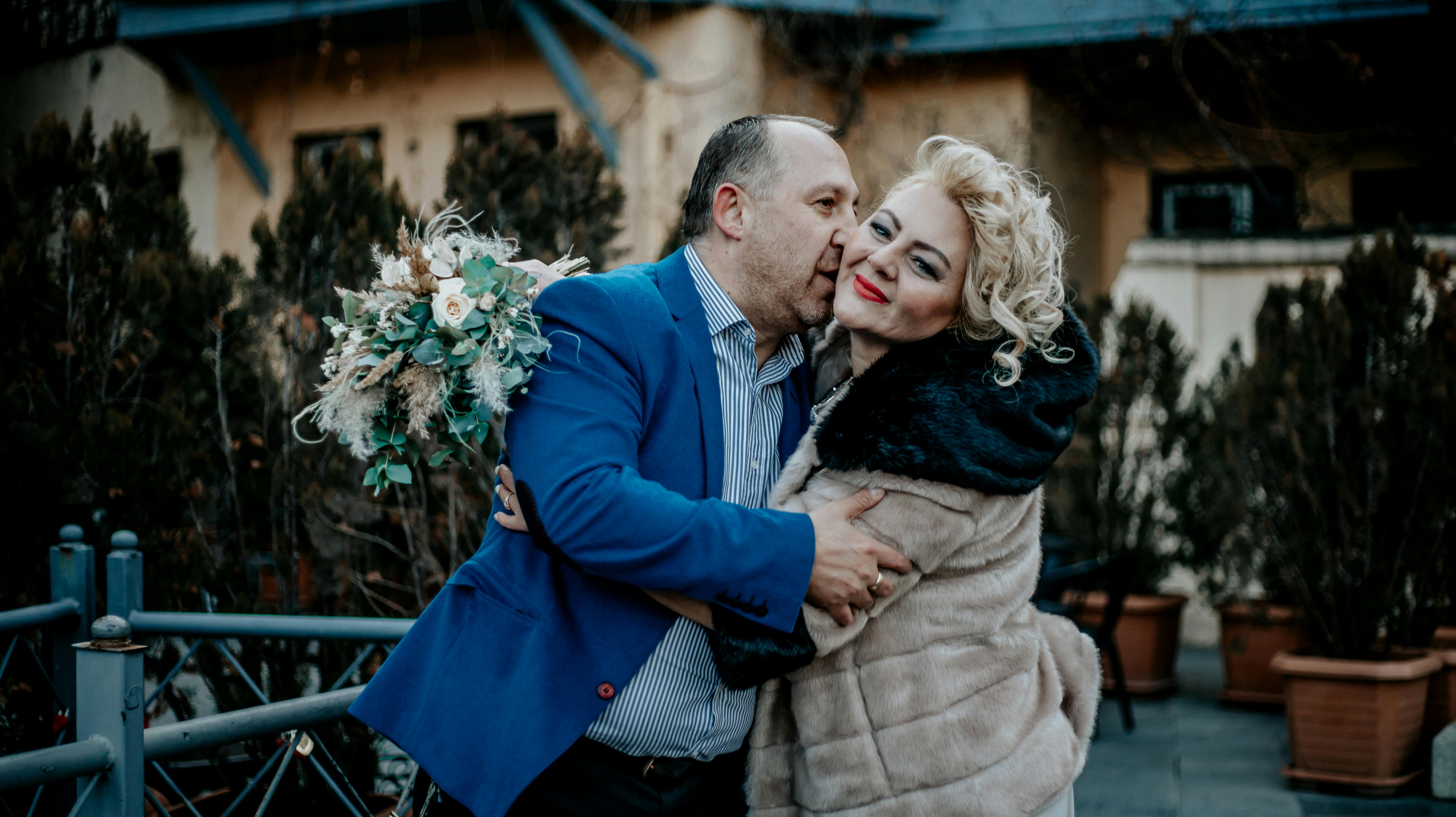 An Elderly Man in Blue Coat Kissing the Woman Wearing Fur Jacket · Free  Stock Photo