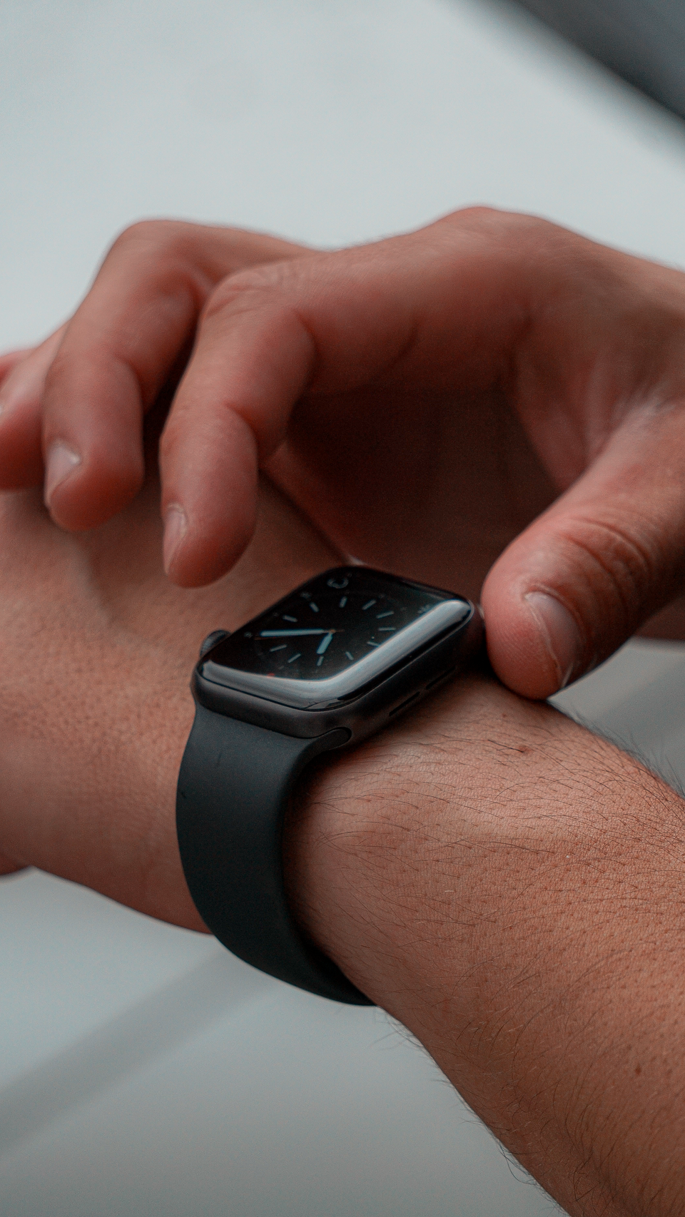 手首のスマートウォッチを調整する場面のイメージ。Apple Watchの通知画面や対応モデルを示す画像ではない