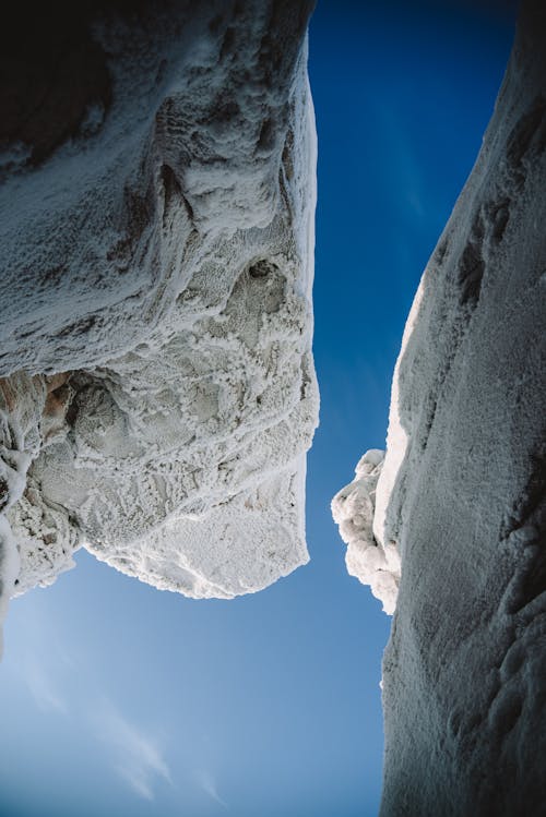 Snow Covered Rock Formations Under Blue Sky