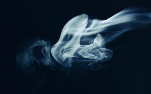 Free Captivating close-up of swirling smoke on a dark background, creating an abstract and mysterious effect. Stock Photo