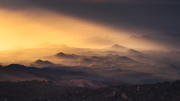 Breathtaking view of mountains at sunset with dramatic light and haze.