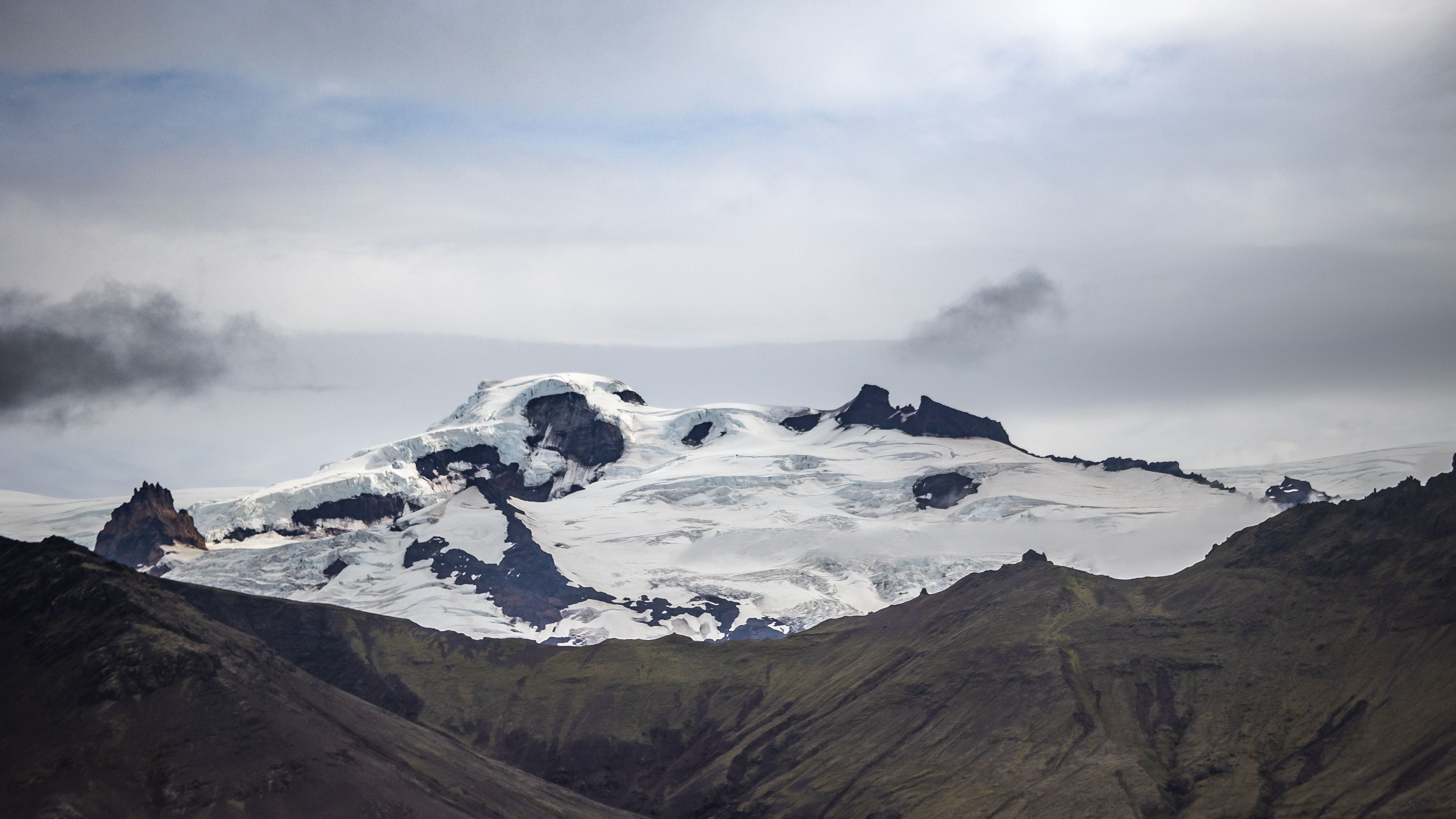 Stunning panorama of a snow-covered mountain under a cloudy sky in Iceland.
