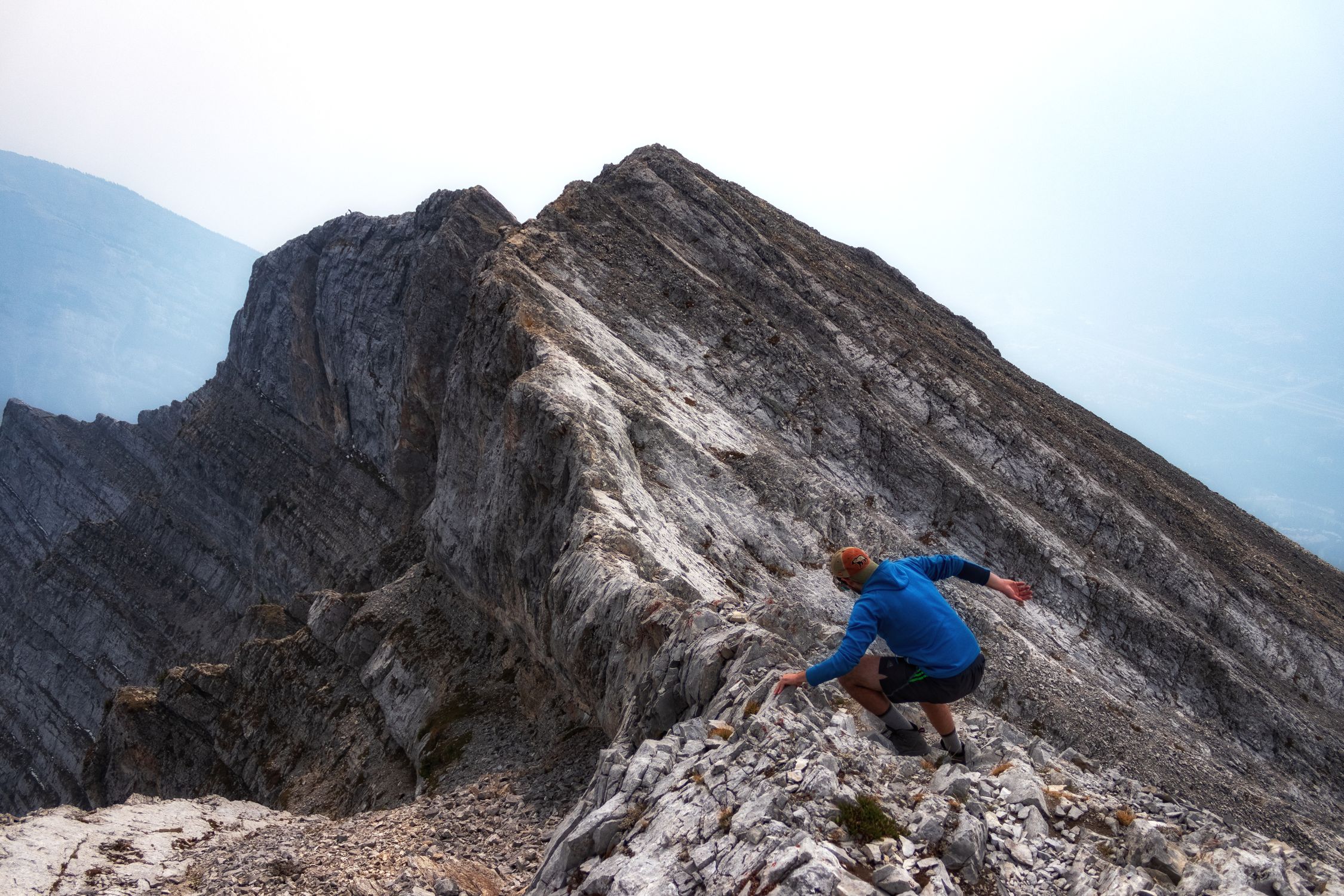 Dynamic shot of a man climbing a rugged mountain ridge in Alberta Canada Dynamic shot of a man climbing a rugged mountain ridge in Alberta Canada