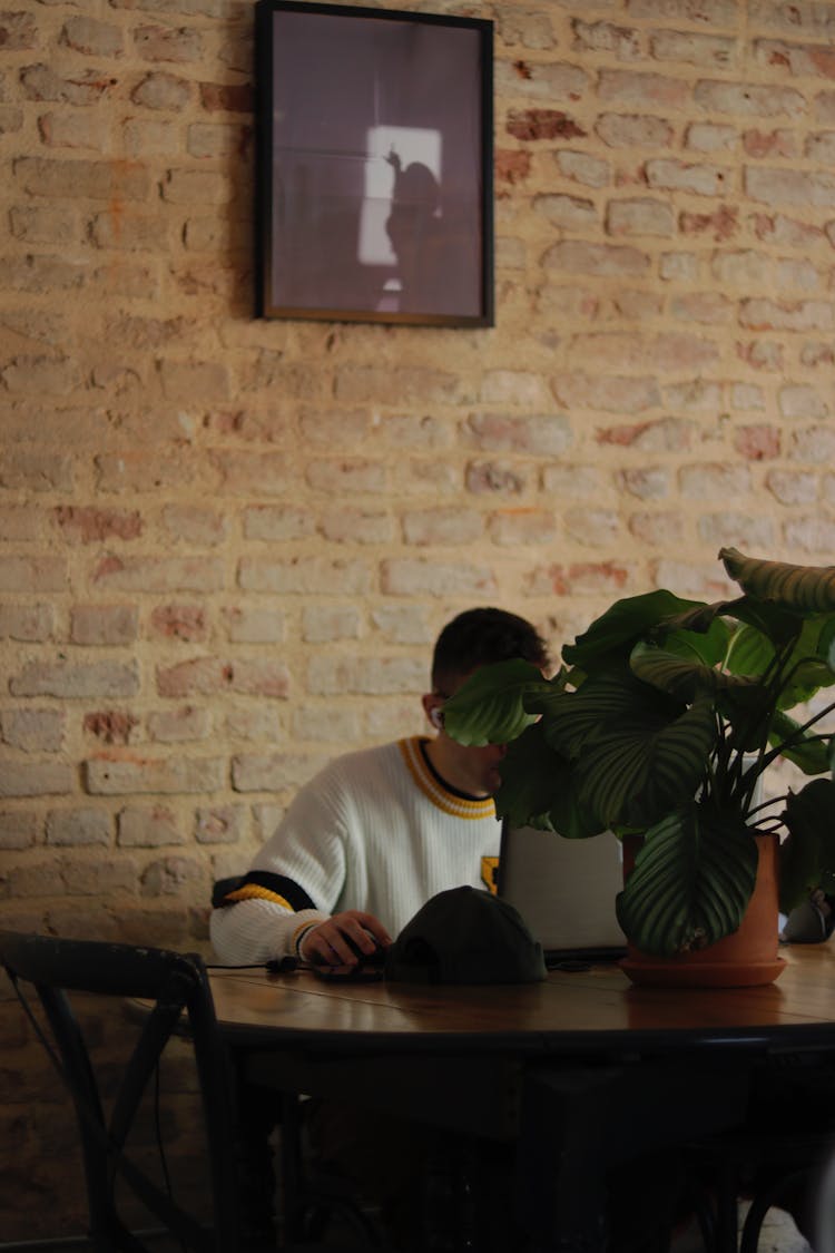 Man Sitting Under Picture On Wall