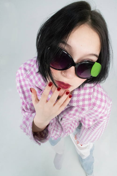A Woman in Pink and White Long Sleeve Shirt Wearing Black Sunglasses