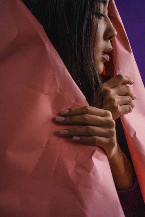 A Woman Covering Her Self Using Pink Paper