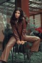 Woman In Leather Jacket and Pants Sitting on Stool
