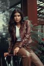 Woman In Leather Jacket and Pants Sitting on Stool