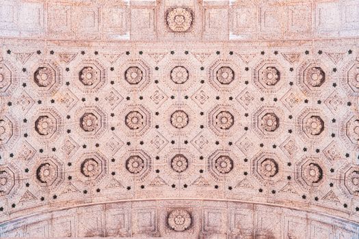 Close-up of an intricate ornamented ceiling with geometric patterns viewed from directly below.