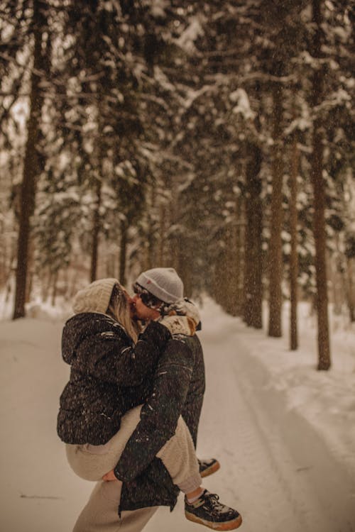 A Couple Kissing While Snowing 