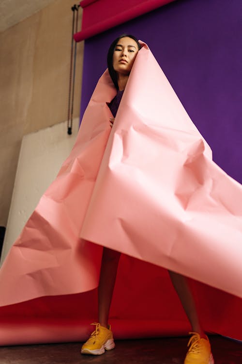 Free Young Brunette Woman Wrapped in Big Sheet of Pink Paper  Stock Photo