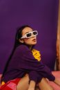 Woman with Long Black Hair in Sunglasses Sitting on Floor 